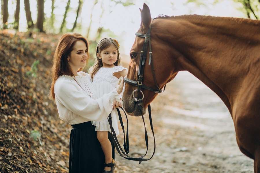 mother and daughter pet horse